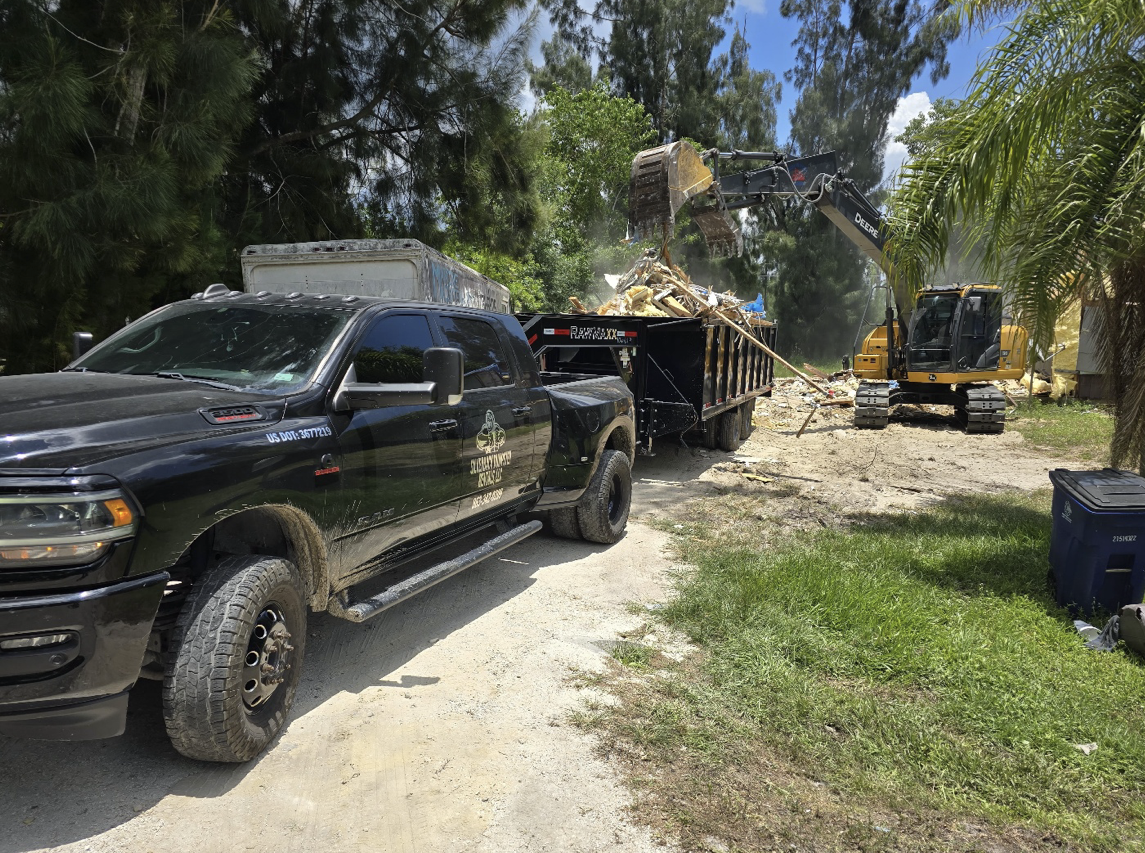 Excavator loading debris into dump trailer